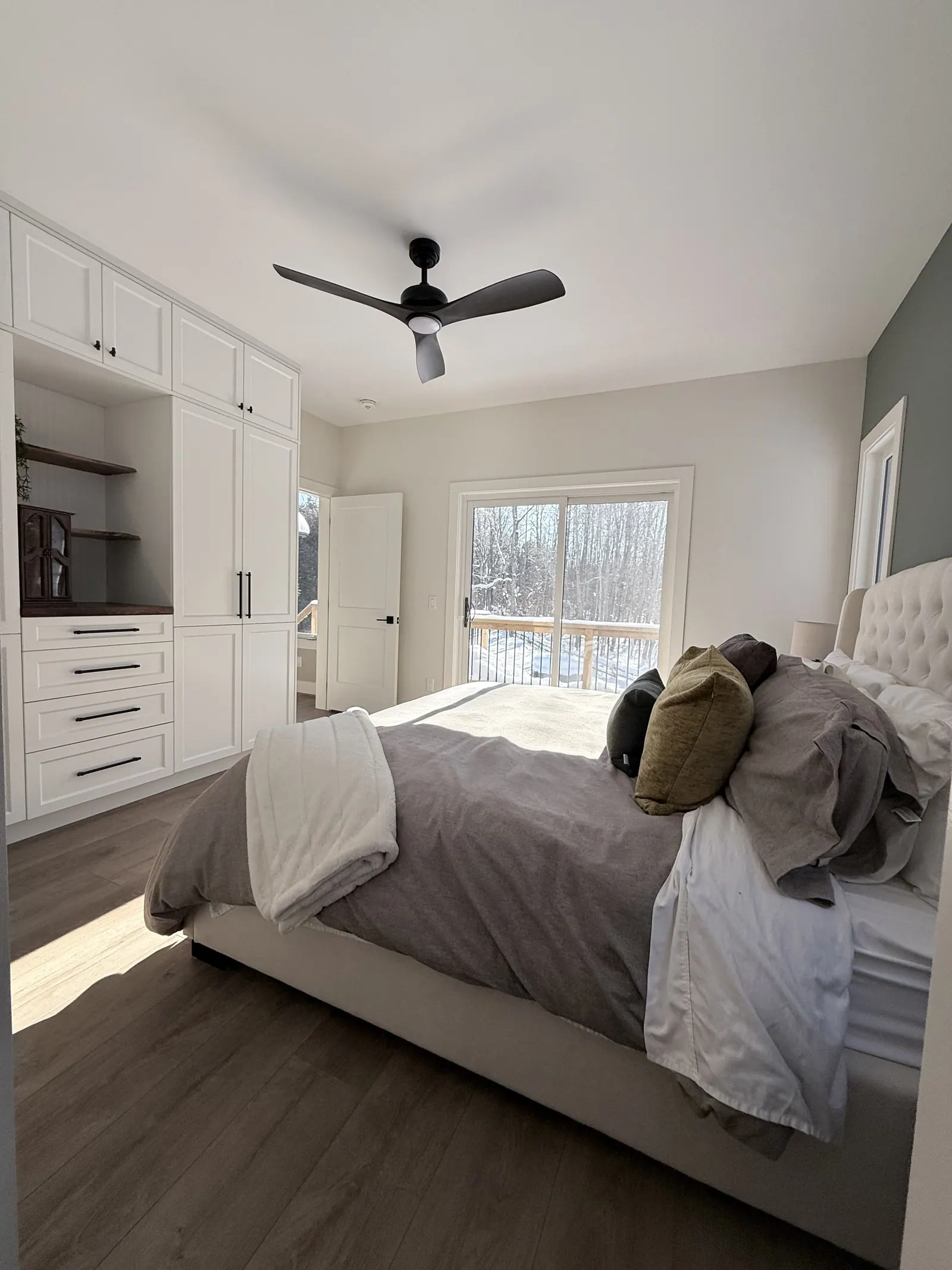 Bedroom with built-in white cabinetry and a view of the deck