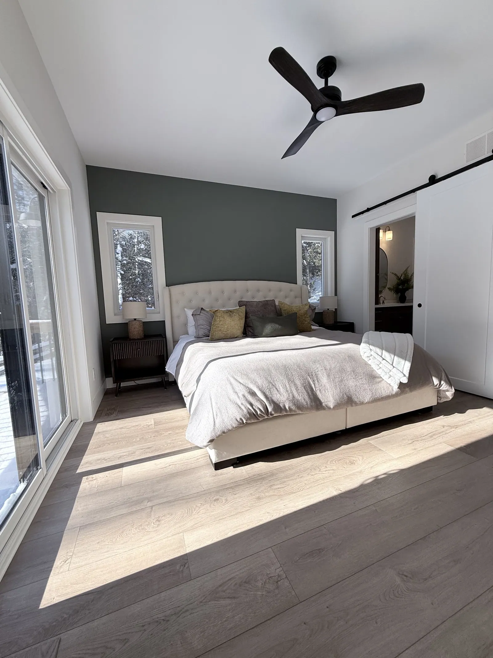 Bedroom with a slate accent wall and a sliding barn door