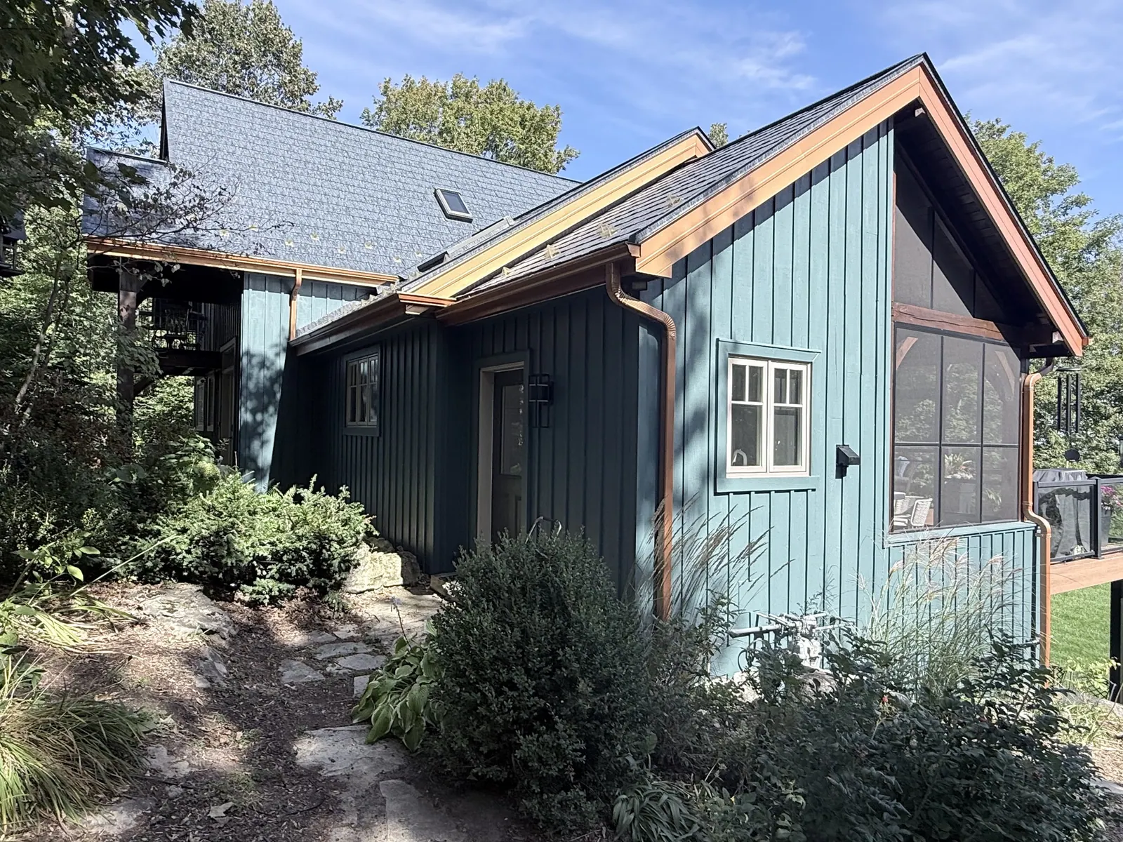 Blue board-and-batten cottage with a screened porch