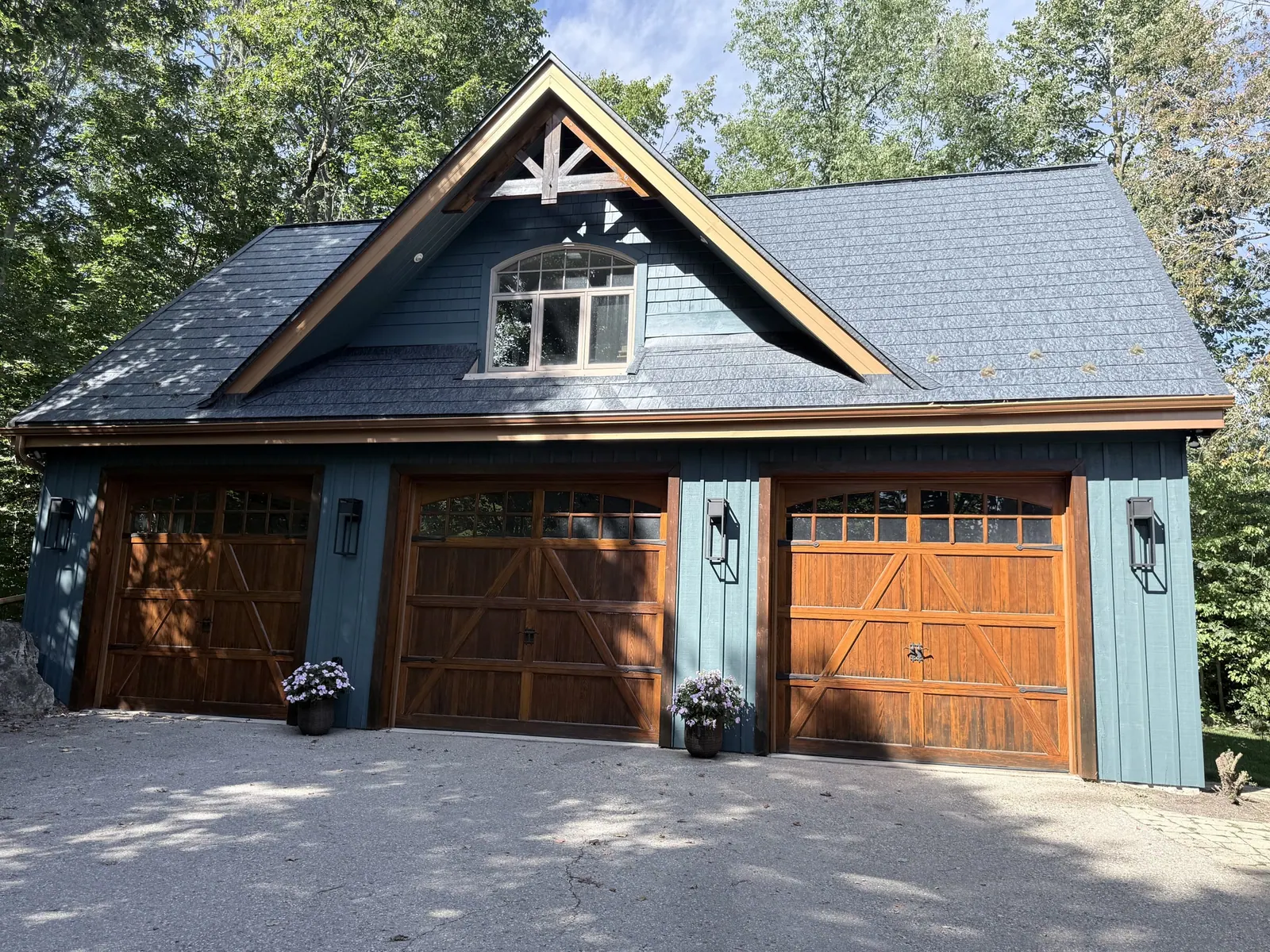 Blue board-and-batten garage with stained wood doors