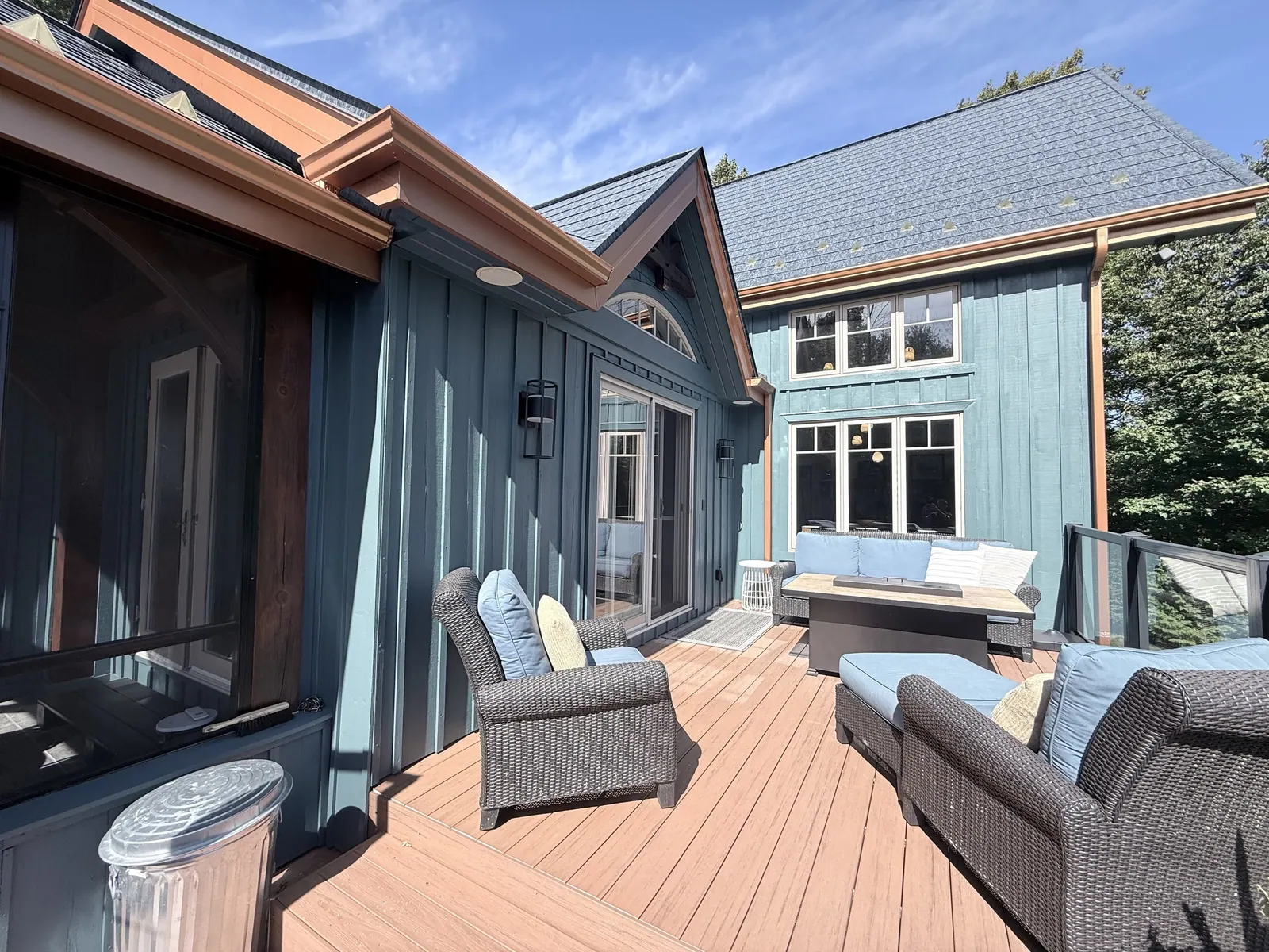 Deck and patio lounge beside a blue house