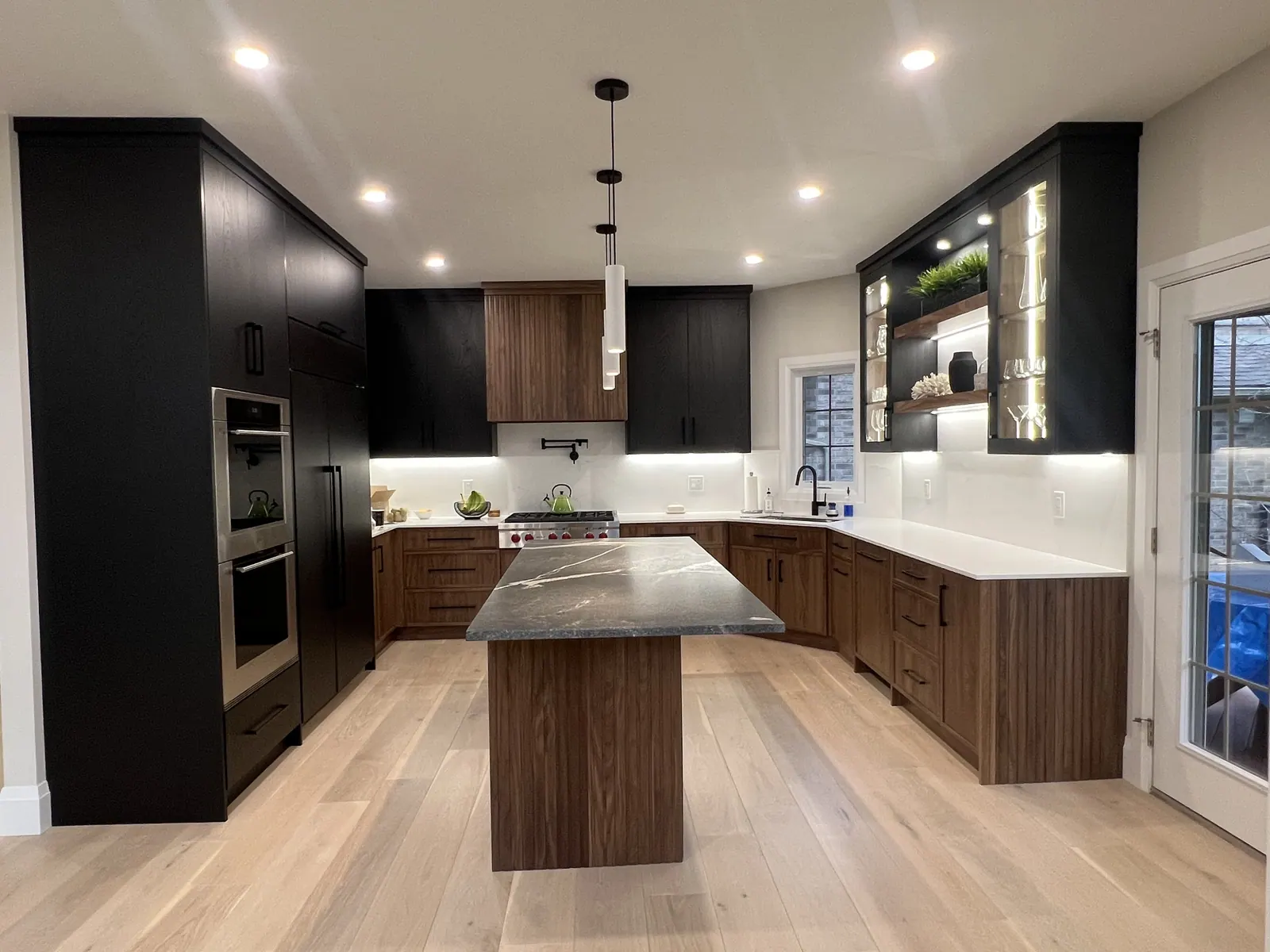 Kitchen with dark cabinetry and a wood island