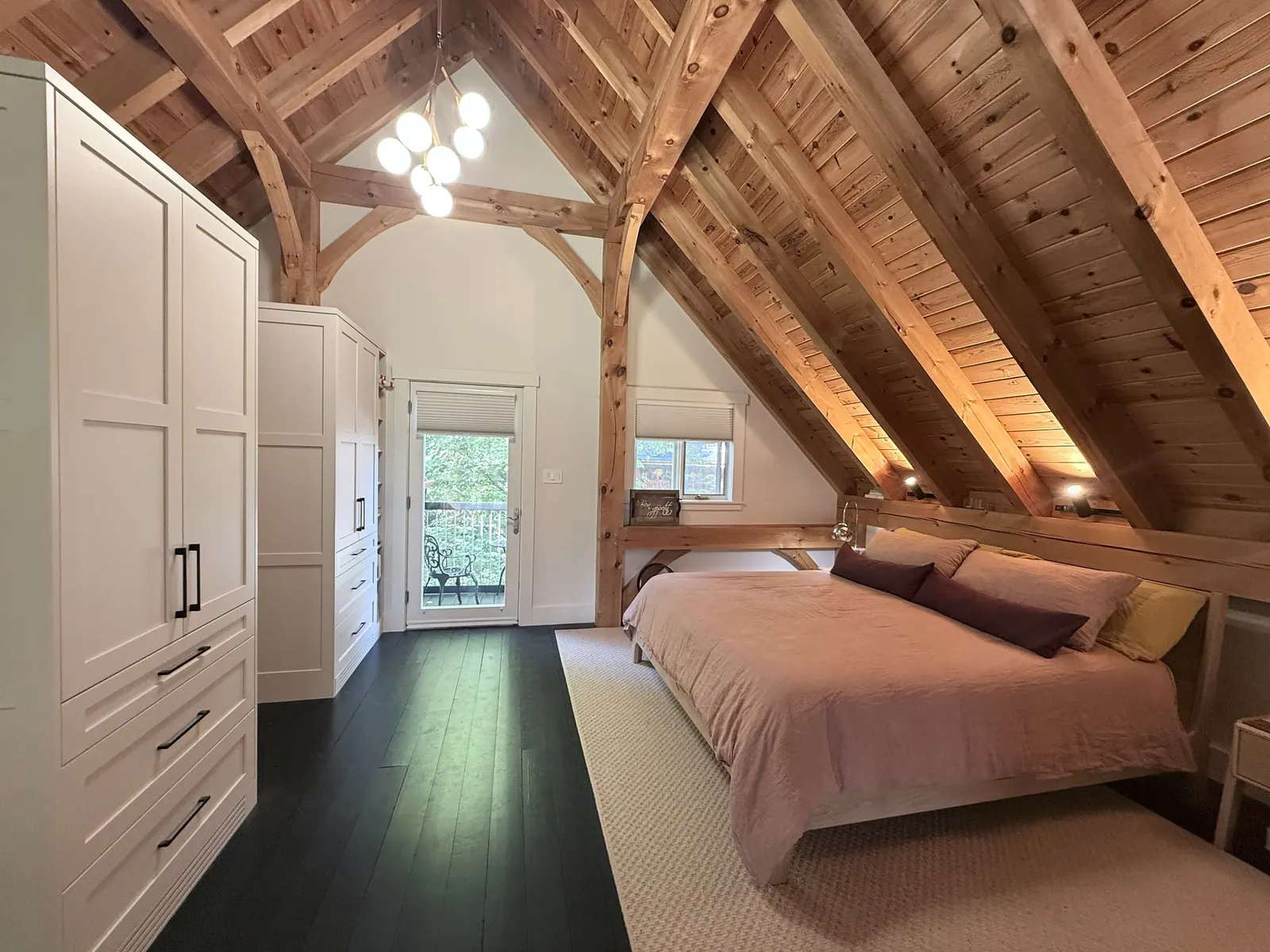 Loft bedroom with exposed timber beams and a built-in wardrobe