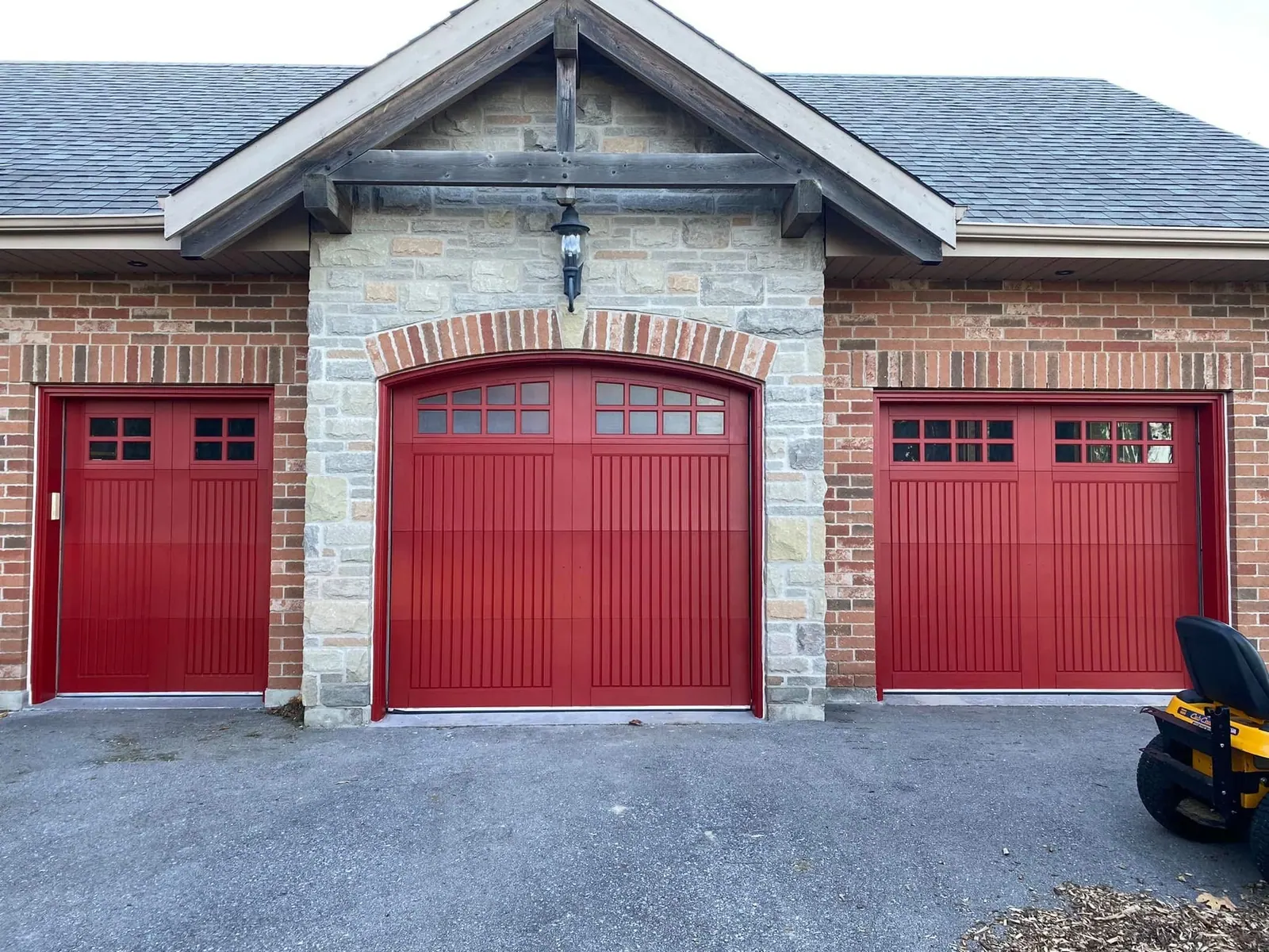 Red painted garage doors on a brick and stone home