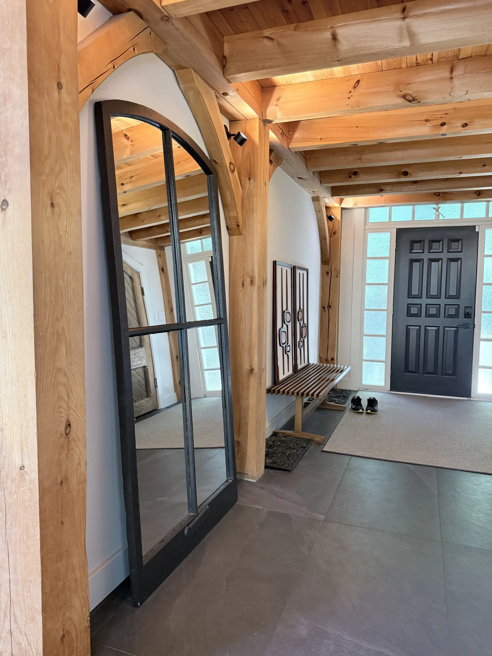 Timber-frame entry with a black front door