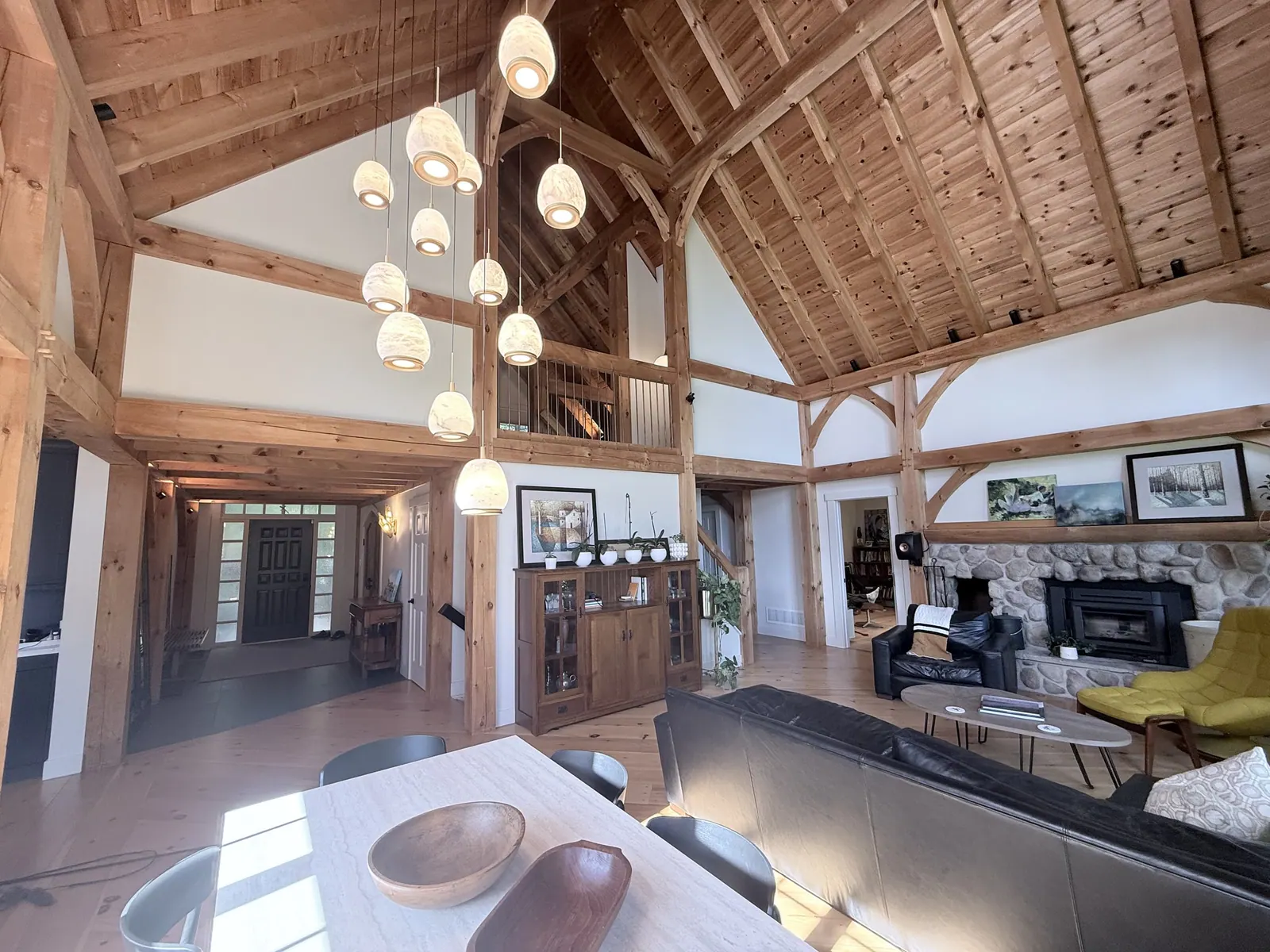 Timber-frame great room with a vaulted ceiling and arched windows