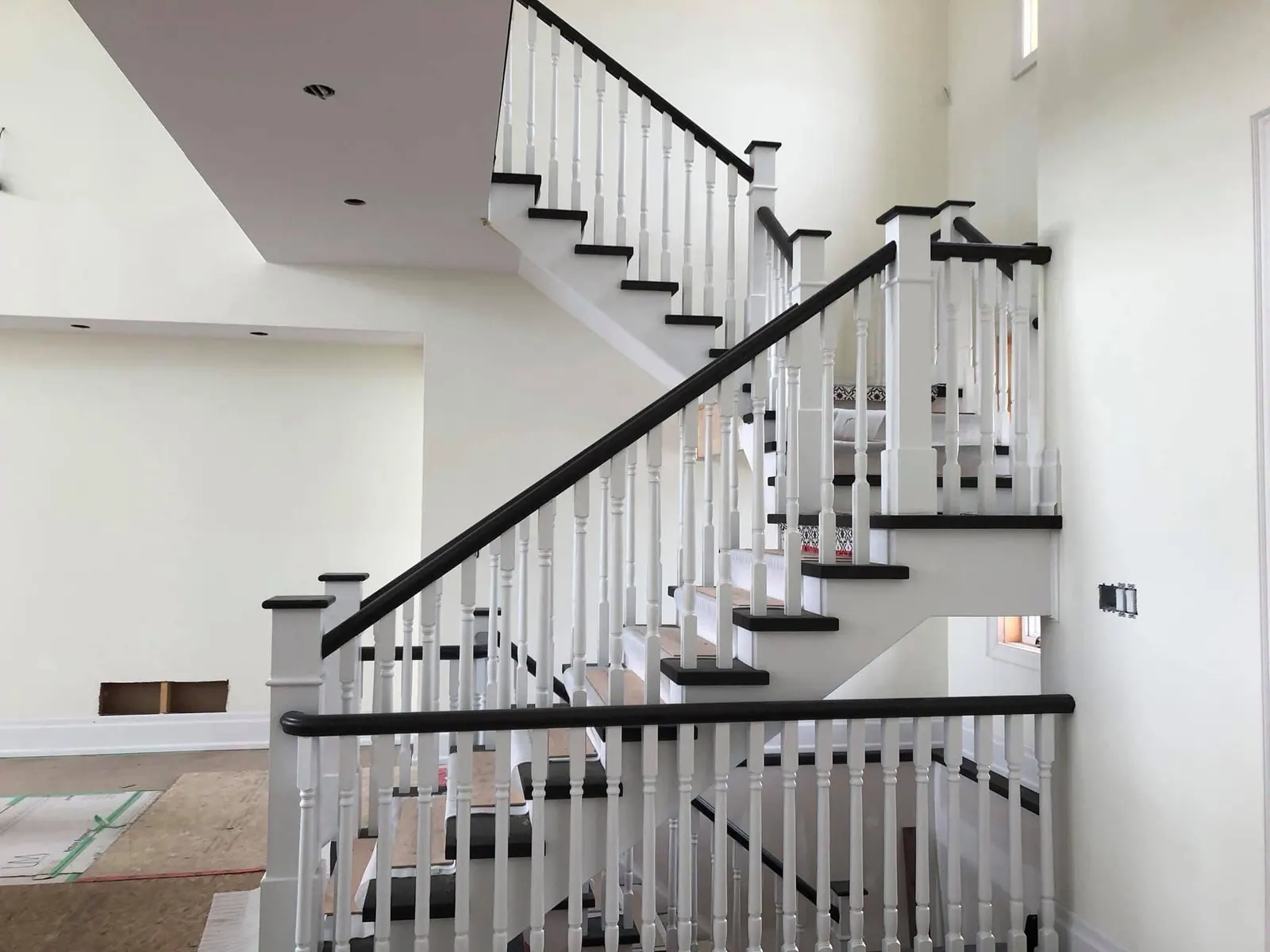 White painted staircase with dark treads and a black railing