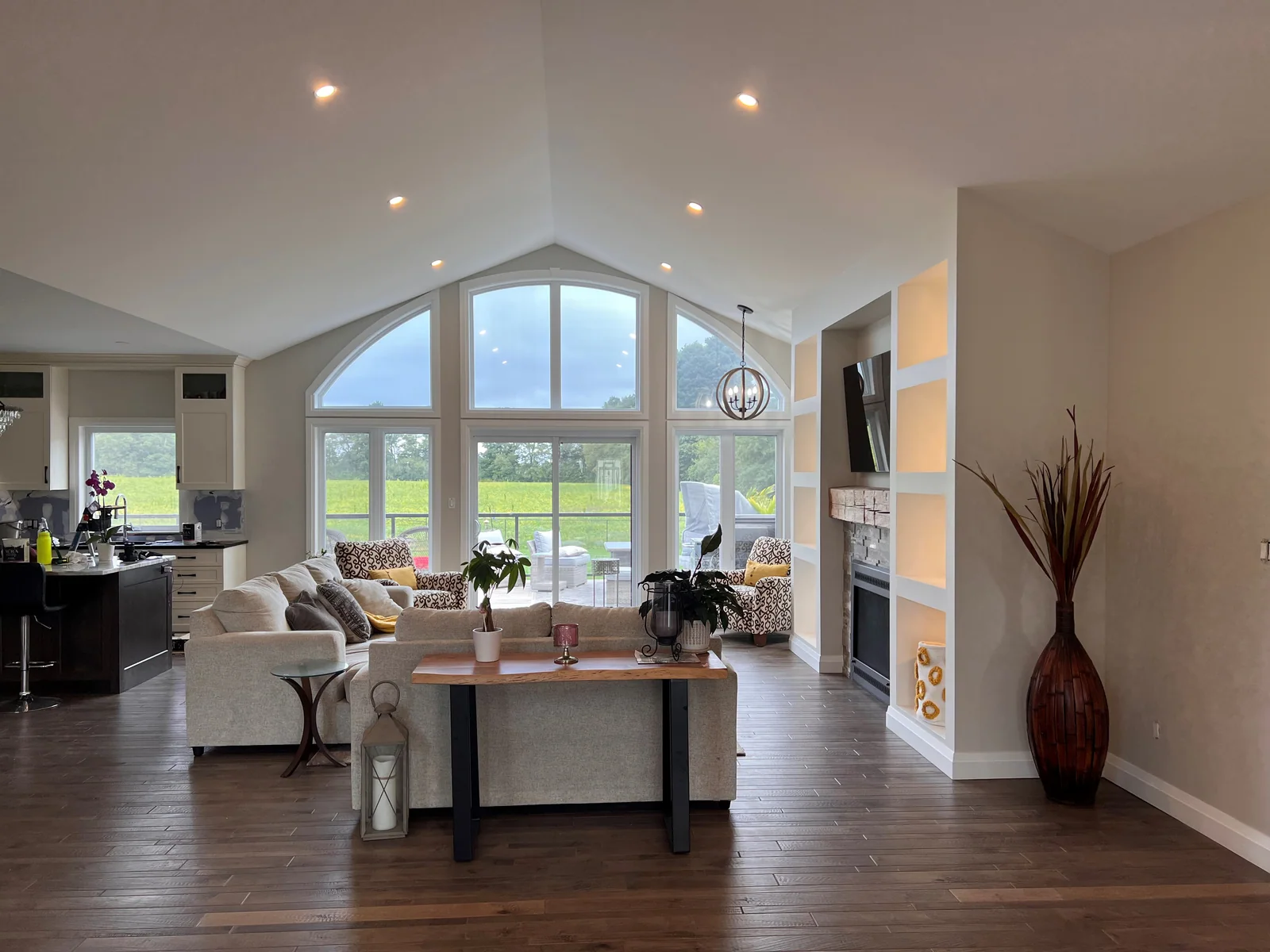 Great room with a vaulted ceiling, arched windows and warm neutral walls